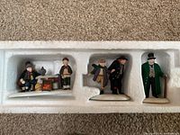 Five Oliver Twist character figurines in original molded styrofoam packaging inside box