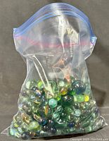 Large freezer bag filled with assorted vintage glass marbles including large croakers and machine made varieties.