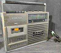 Front quarter view of Eaton Viking cassette tape recorder showing cassette slot, control buttons, carry handle and speaker grille.