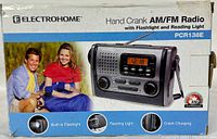 Front view of the Electrohome hand crank AM/FM radio in box showing product branding, model number PCR138E, and key features including built-in flashlight, reading light, and crank charging.