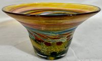 Side view of the striped glass bowl showing the flared rim and multicolor bands.