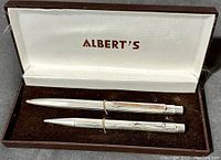 Overview of the sterling silver ballpoint pen and mechanical pencil set in original Albert's box, showing the textured engraved pattern on both pieces.