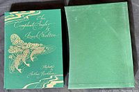 Green hardcover book with gold embossed title and fish image by Arthur Rackham, next to green slipcase.