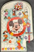Full view of vintage 1950 Mickey Mouse Club marble pinball game showing colorful Disney character illustrations and score zones