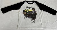 Front view of white T-shirt with black 3/4 length sleeves featuring Prince on motorcycle with Purple Rain text.