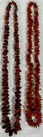 Two vintage amber necklaces lying flat against a white background, showing color and bead size variation