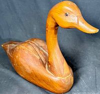 Full view of vintage wood carved Canadian duck decoy showing body shape, neck, and glass eyes