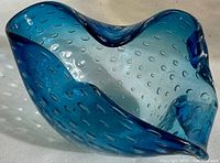 Top and side views of a cobalt blue hand blown glass bowl with bubble pattern and organic wavy edges.