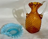 Photo showing both the blue hobnail bon bon dish and the amber hand blown glass vase side by side on a white surface.