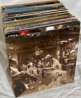 Stack of vinyl records showing sepia-tone bar scene album cover prominently.