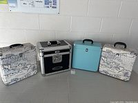 Front view of all four cases side by side: map print, black Ody USA, turquoise, map print