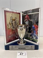 Three-panel acrylic display containing replica trophy and printed panels