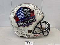 Front view of white helmet with Hall of Fame logo and multiple signatures