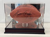 Front view of signed football inside acrylic display case