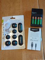 Photo showing Duracell AA rechargeable batteries in charger, AmazonBasics USB-A to Lightning cable in packaging, and multi-purpose cable clips set.