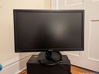 Front view of ASUS VP228HE monitor powered off, showing its black frame and screen on a circular stand.