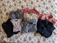 Top view of 7 men's shirts in assorted colors and patterns laid on floral bedspread.