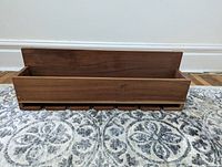 Front view of the solid wood shelf showing slots for 6 stem wine glasses underneath and compartment for wine bottles.