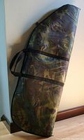 Zippered camouflage bow case laid flat showing full length and carry straps