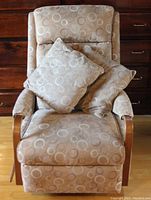 Front view of one rocker recliner chair with two matching cushions placed on seat.