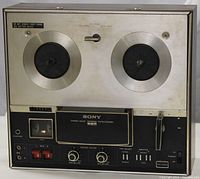 Front view of Sony TC 353D reel-to-reel tape recorder showing dual reel hubs, control panel, and speaker.