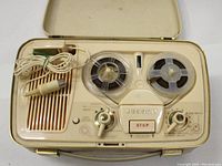 Top view of Grundig TK1 reel-to-reel tape recorder showing reels, speaker, controls, and microphone