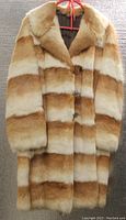 Front view of vintage rabbit fur coat showing striped pattern and button details