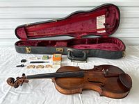 Full lot overview showing violin, case and accessories laid out