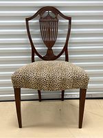 Front view of antique shield back chair with leopard print seat upholstery showing overall design and condition.