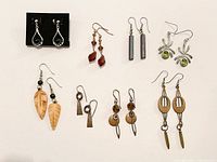 Photo showing 8 pairs of earrings with various shapes and materials, with stainless steel or silver hooks, as described by seller.