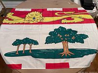 Full view of Prince Edward Island flag laying flat showing main lion and tree design.