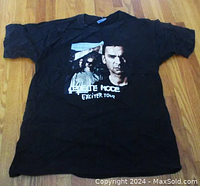 Full view of black Depeche Mode Exciter Tour 2001 T-shirt laid flat on wood floor, showing front graphic and text.