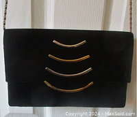 Front view of black velvet evening bag showing gold and silver semi-circle metal embellishments on flap.