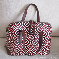 Front and top view of Fossil Sydney Satchel showing red, navy blue and cream geometric design with brown leather handles and base.