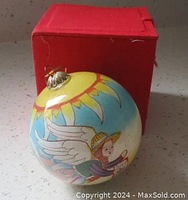 Ornament with garden angel and sunflower design shown outside the box to display artwork and condition.