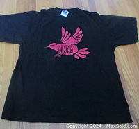 Black Incubus t-shirt with red crow graphic and band name, laid flat on floor