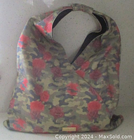 Front view of Peace Love World canvas hobo bag showing camo and rose print and overall bag shape.