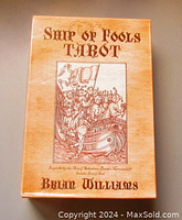 Photo of the front of the Ship of Fools Tarot box by Brian Williams. Shows vintage style sepia box with artwork of a ship filled with figures and the title text.