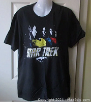Front view of black Star Trek T-shirt on mannequin showing colorful graphic with original cast faces and STAR TREK logo.
