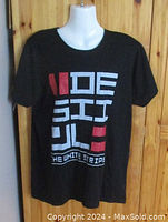 Front view of the black t-shirt showing The White Stripes De Stijl album design in white and red print.