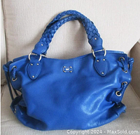 Front view of the bright blue Michael Kors leather tote with braided handles and tassels, showing overall condition and shape.