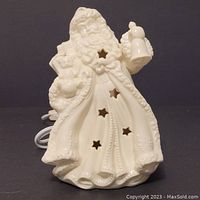 Front view of white ceramic Santa Claus Christmas light with star-shaped cutouts and attached electrical cord.