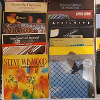 Photo of Classic Rock vinyl LPs stacked tightly, showing album covers including Steve Winwood, The Beatles, Genesis, Gerry Rafferty, Bread, Cat Stevens, and Harry Chapin albums.