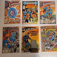 Six classic Superman comic books laid out showing various cover artwork and titles
