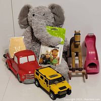Wide shot showing all items including elephant buddy, red truck warmer, yellow Hummer, rocking horse, and pink shoe tape dispenser