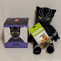 Scentsy Black Panther Buddy plush seated next to its original box and the Disney The Muppets scent pack.