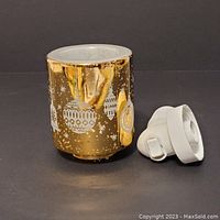 Ceramic gold-colored night light with white holiday ornament designs and separate white plastic plug-in base.