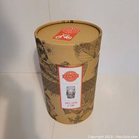 Cylindrical box with botanical and geometric designs labeled Scentsy Once Upon A Time, showing the box packaging.