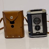 Brownie Reflex Synchro camera next to brown leather carrying case