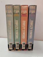 Four VHS tapes of Fawlty Towers showing the spine with CBS Fox Video and BBC Video logos and different pastel spine colors.